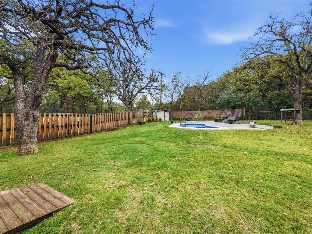 206 Navajo Trail Hamilton, TX 76531 - Photo 34 of 39 Fenced backyard featuring a storage unit and a patio area