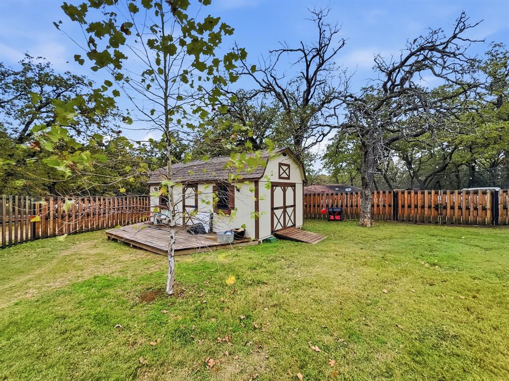 206 Navajo Trail Hamilton, TX 76531 - Photo 35 of 39 Fenced backyard with a storage shed