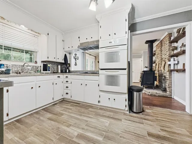 a kitchen with stainless steel appliances kitchen island granite countertop a refrigerator and cabinets