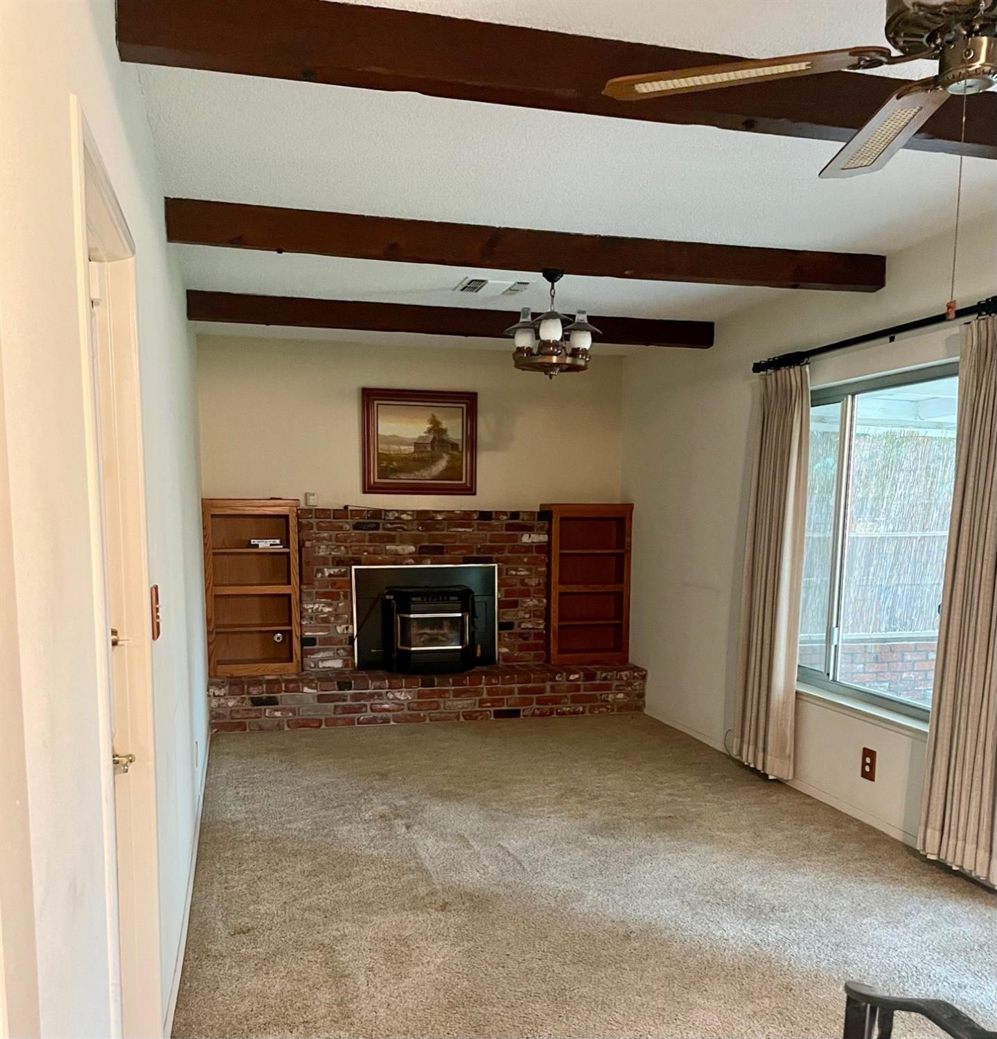 230 West Spring Lane Lemoore, CA 93245 - Photo 7 of 14 a view of an empty room with a fireplace and a window