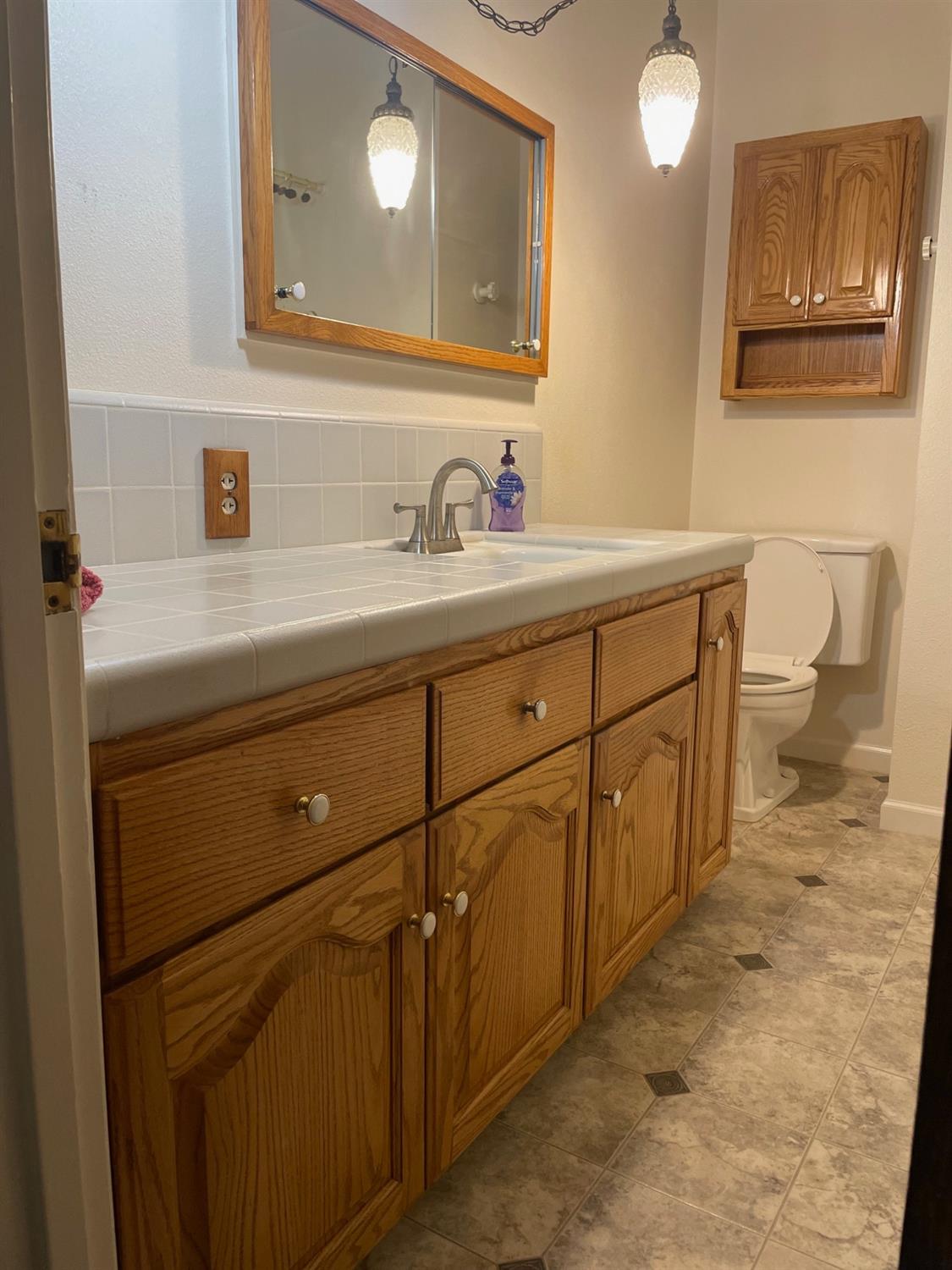 230 West Spring Lane Lemoore, CA 93245 - Photo 9 of 14 a bathroom with a sink and a mirror