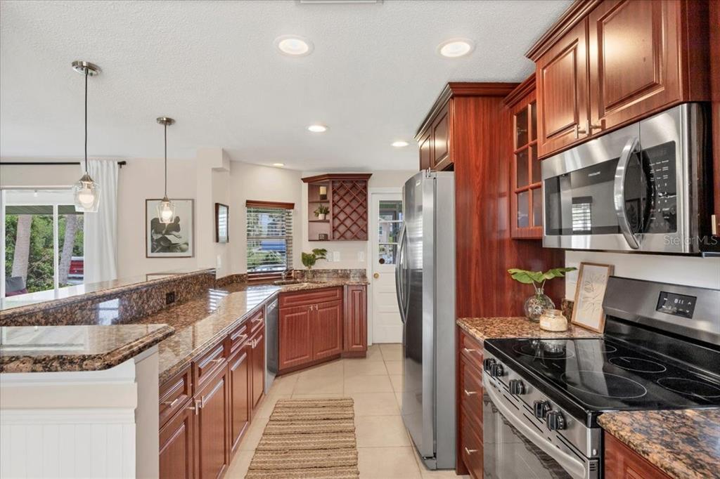 4696 Pompano Street Placida, FL 33946 - Photo 6 of 23 a kitchen with stainless steel appliances granite countertop a stove and a refrigerator