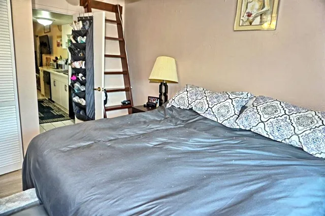 a bedroom with window and flat screen tv