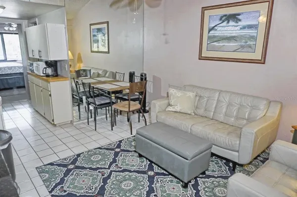 a living room with furniture a dining table and paintings on the wall