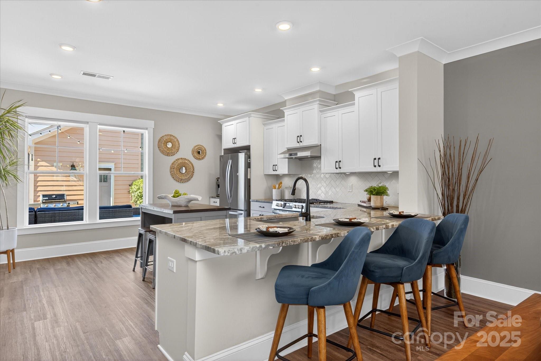 676 Dunkins Ferry Road Rock Hill, SC 29730 - Photo 14 of 47 a kitchen with stainless steel appliances granite countertop a stove top oven a sink a dining table and chairs with wooden floor
