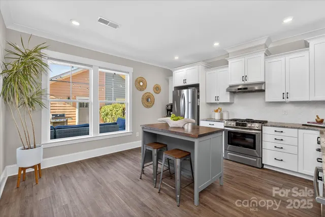 a kitchen with stainless steel appliances granite countertop a sink stove and cabinets