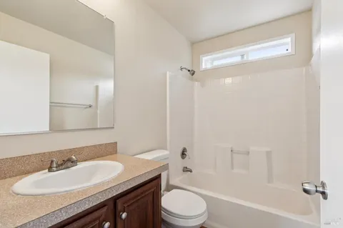 a bathroom with a granite countertop sink toilet a mirror and shower