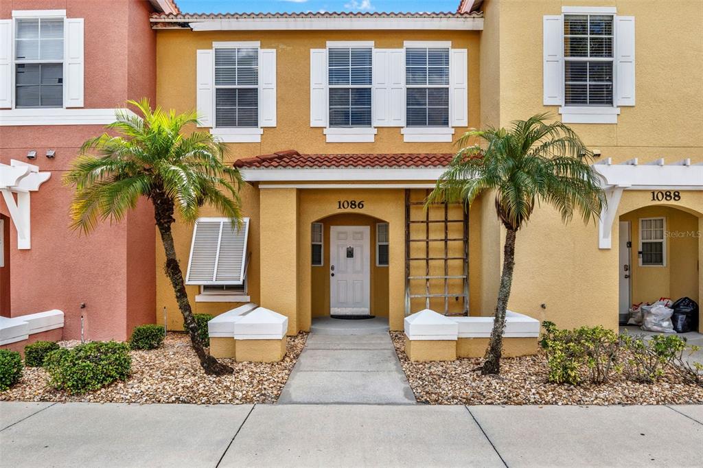 a front view of a house with a yard and potted plants