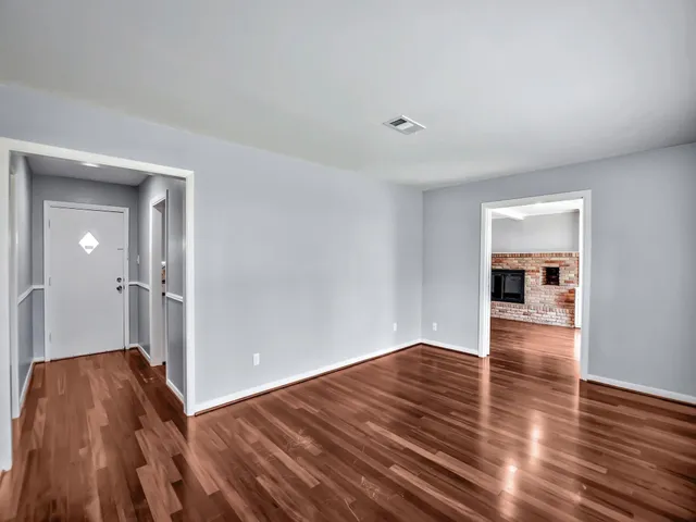 a view of a room with wooden floor and a window