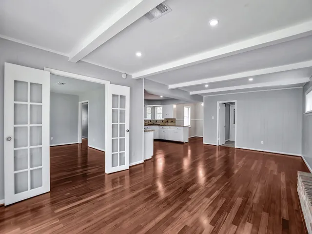 a view of empty room with wooden floor