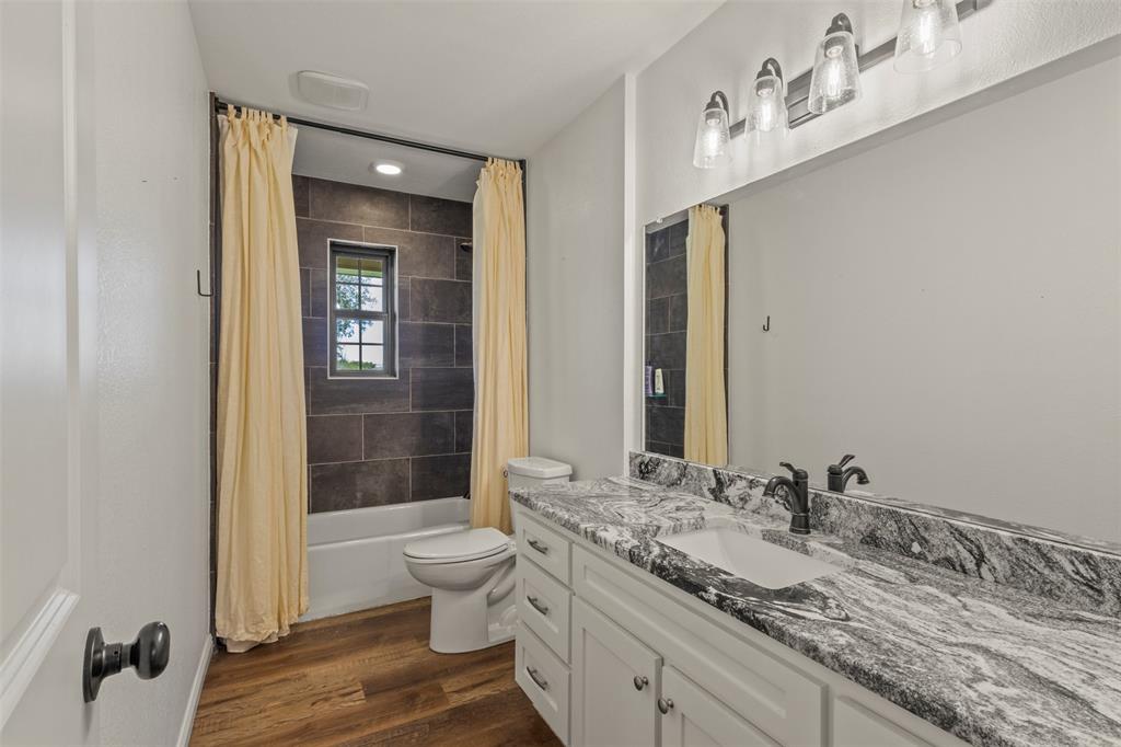 3009 Ranch House Road Willow Park, TX 76087 - Photo 17 of 40 a bathroom with a granite countertop sink a toilet and shower