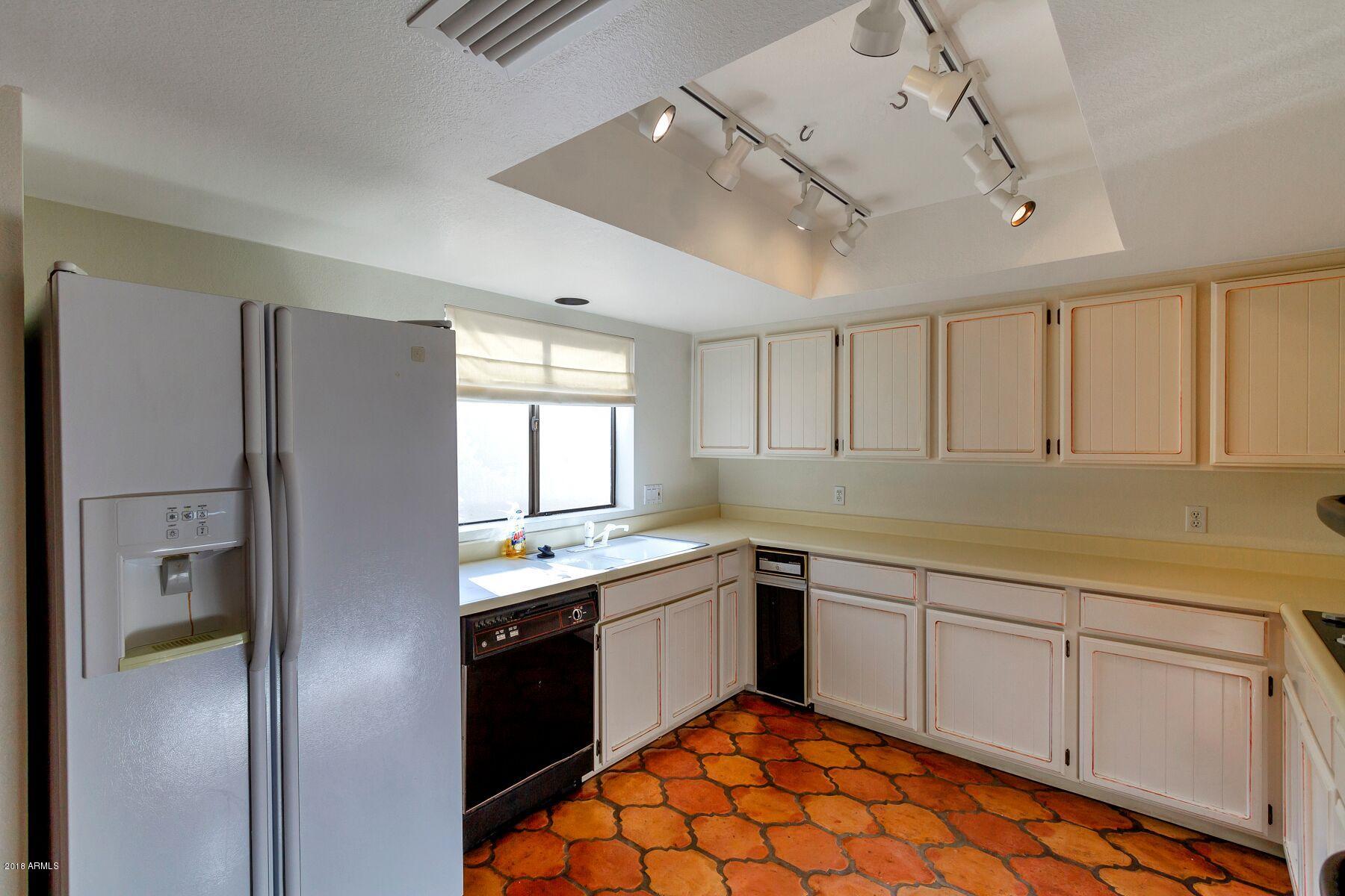 5310 North 24th Place Phoenix, AZ 85016 - Photo 13 of 21 a kitchen with stainless steel appliances granite countertop a refrigerator a sink dishwasher a stove and white cabinets with wooden floor