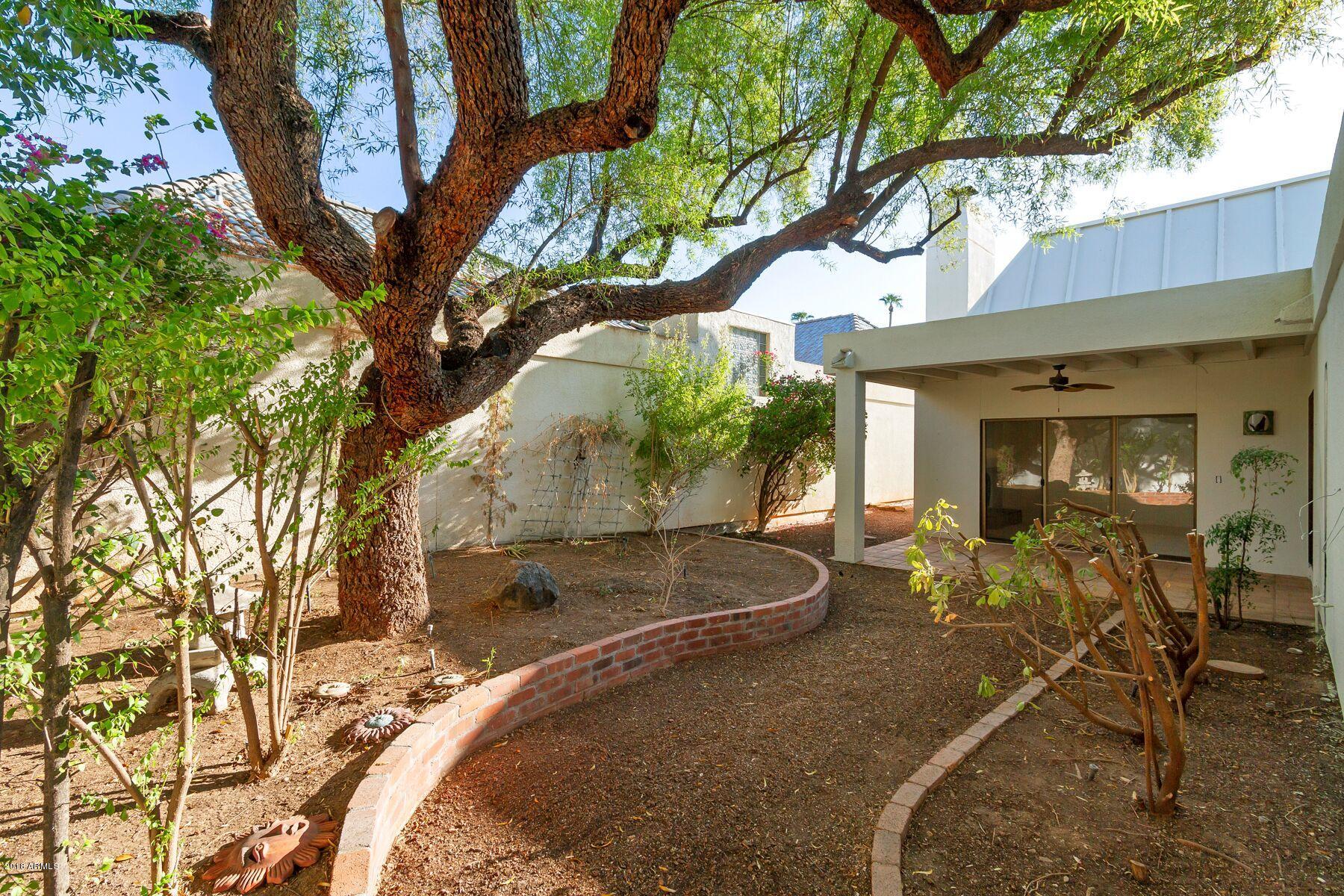 5310 North 24th Place Phoenix, AZ 85016 - Photo 21 of 21 a backyard of a house with table and chairs and a large tree