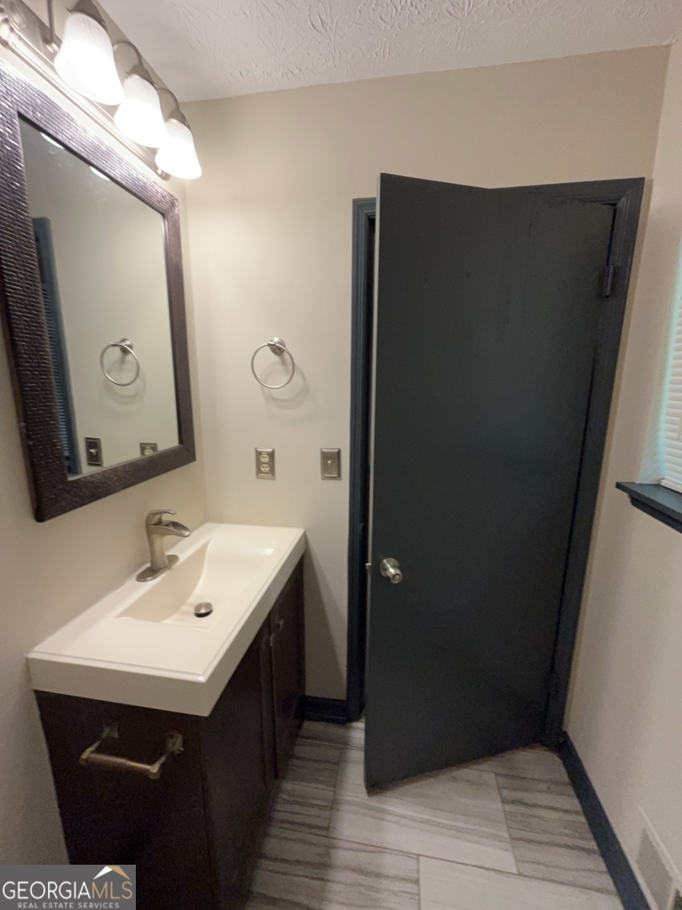 1265 Herrington Road Lawrenceville, GA 30044 - Photo 35 of 52 a bathroom with a sink and a mirror