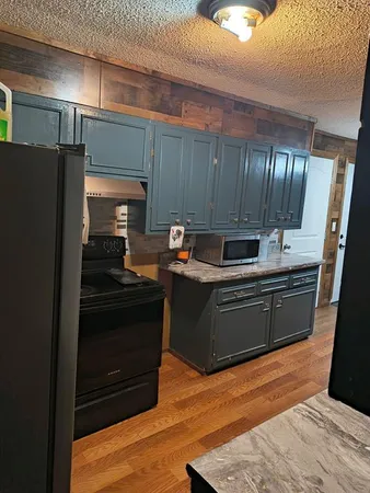 a kitchen with granite countertop stainless steel appliances and wooden cabinets