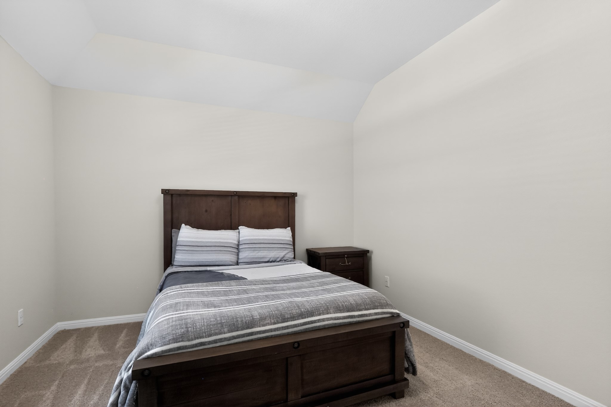 114 Bosco Road Hutto, TX 78634 - Photo 25 of 39 A well-lit bedroom offering plush carpeting and a sloped ceiling for architectural interest.