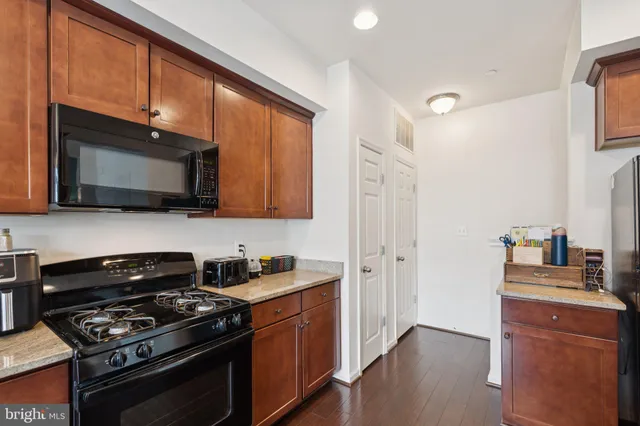 a kitchen with stainless steel appliances wooden cabinets and a stove top oven