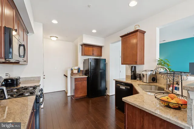 a kitchen with stainless steel appliances granite countertop a refrigerator a stove top oven a sink and dishwasher