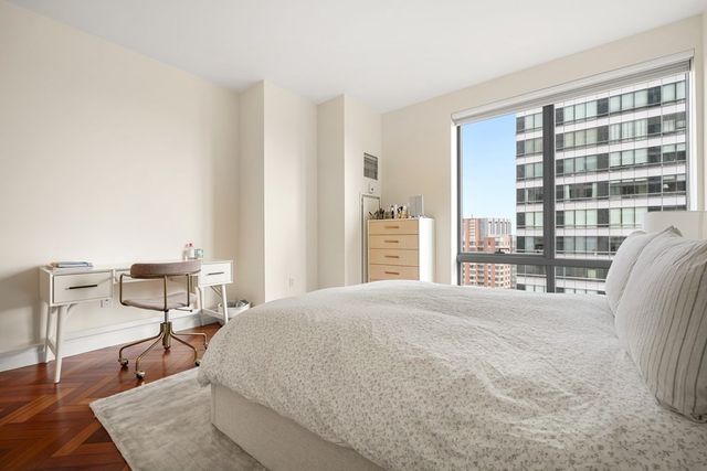 a spacious bedroom with a bed and chair