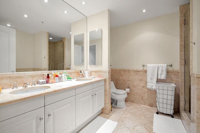 a bathroom with a double vanity sink mirror and toilet