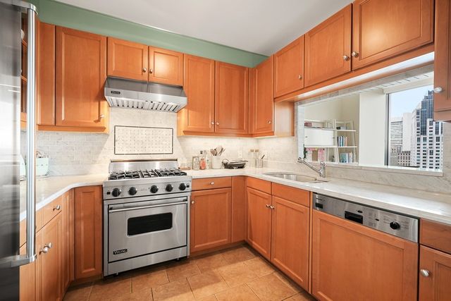 a kitchen with stainless steel appliances a stove a sink and cabinets