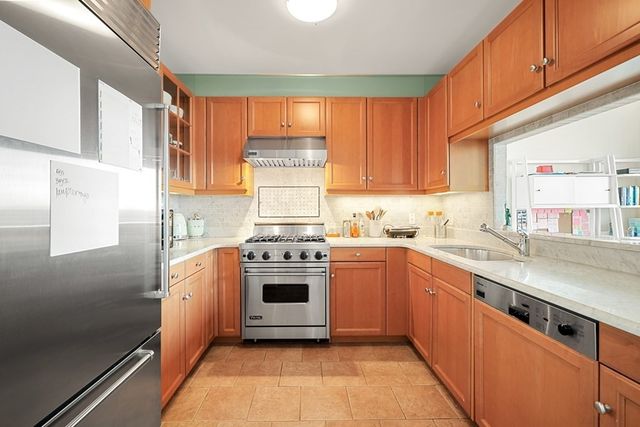 a kitchen with stainless steel appliances granite countertop a stove a sink and a refrigerator