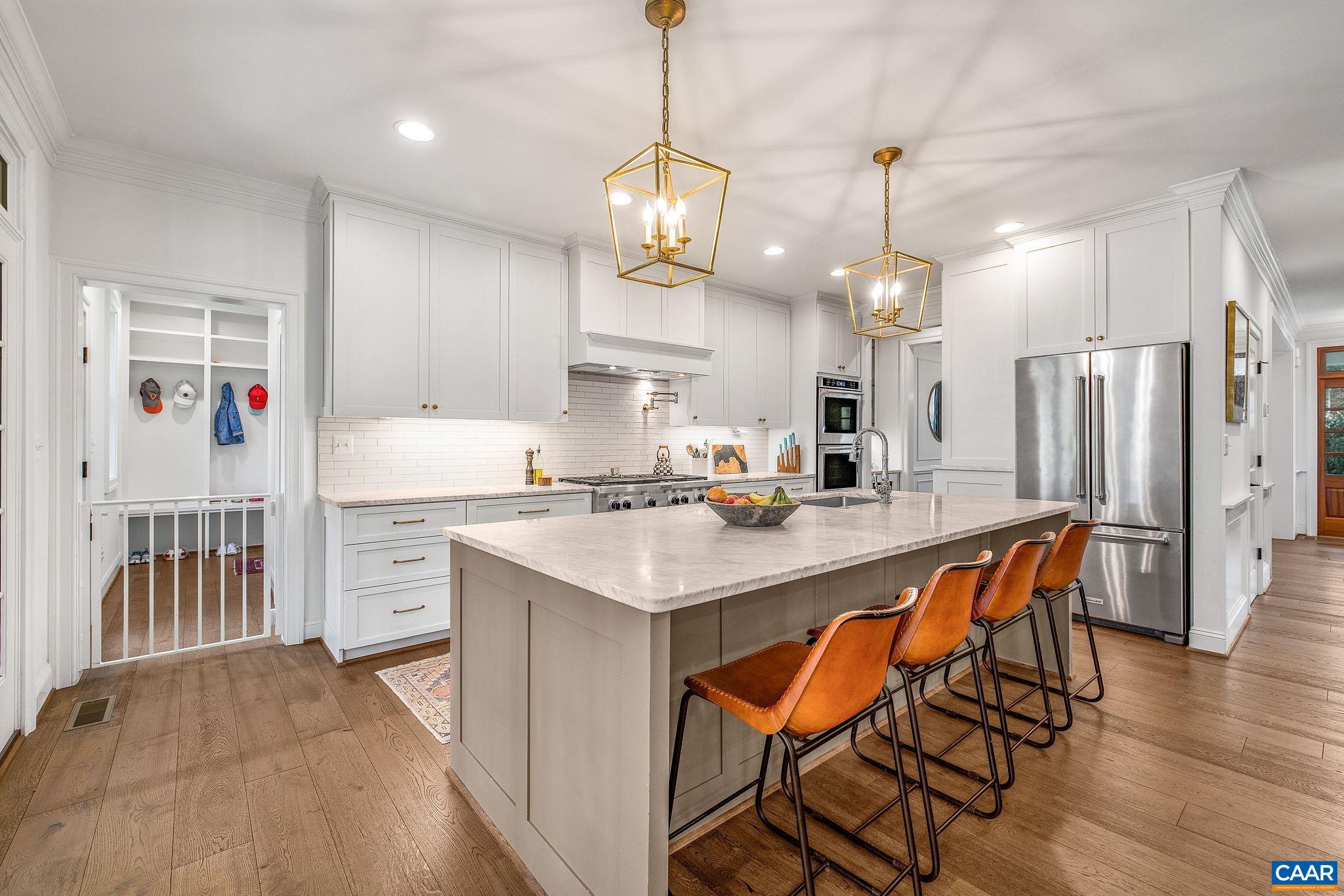 1421 Dairy Road Charlottesville, VA 22903 - Photo 11 of 57 a kitchen with stainless steel appliances kitchen island granite countertop a dining table chairs and white cabinets