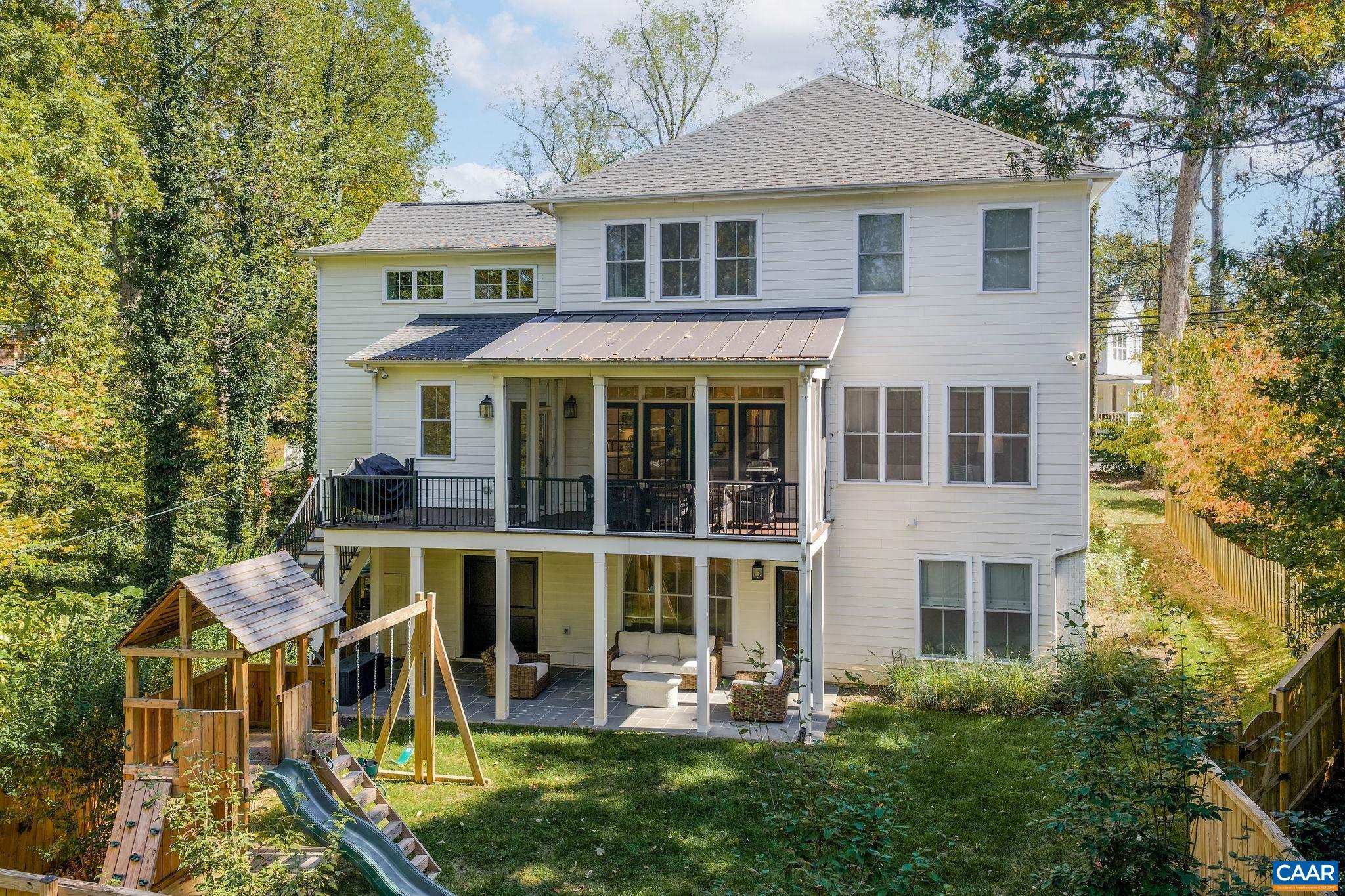 1421 Dairy Road Charlottesville, VA 22903 - Photo 47 of 57 a view of a white house with large windows and a table and chairs under an umbrella