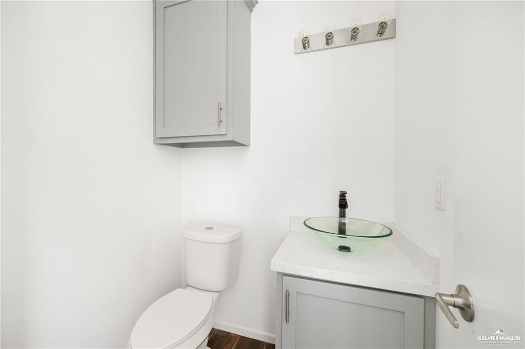2105 Azalea Street Mission, TX 78573 - Photo 12 of 14 a bathroom with a toilet sink and mirror
