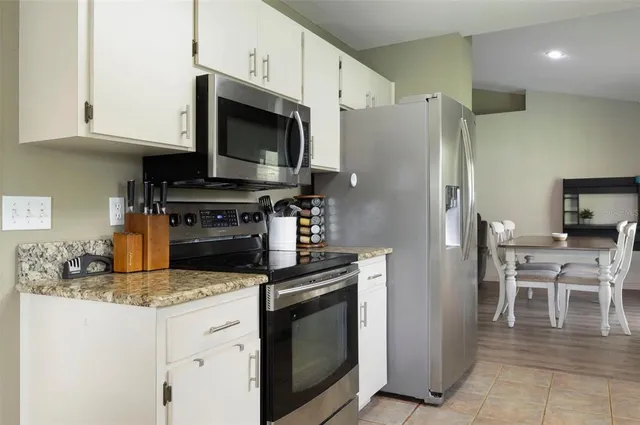 a kitchen with stainless steel appliances granite countertop a stove a refrigerator and a microwave
