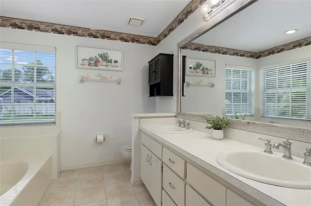 a spacious bathroom with double vanity a mirror and a shower