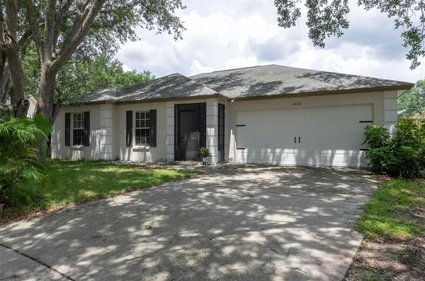 a view of a house with yard and tree s