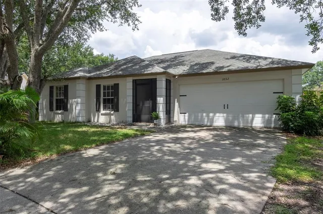 a view of a house with yard and tree s