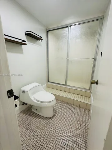 a bathroom with a toilet and a shower