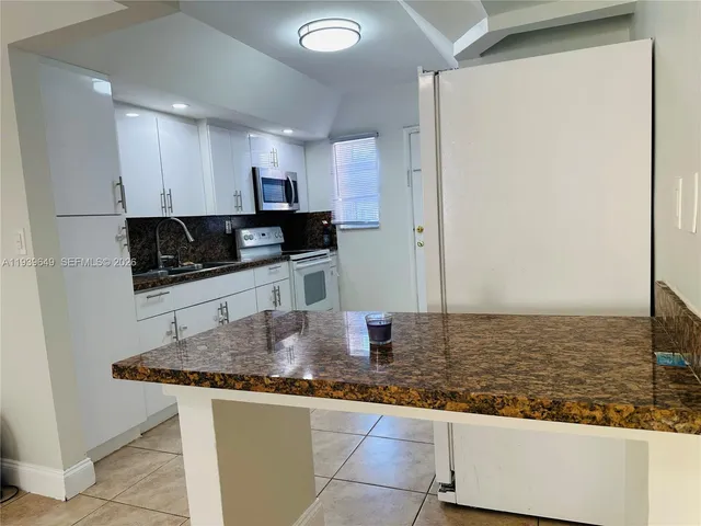 a kitchen with stainless steel appliances granite countertop a sink and a stove