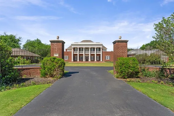 a front view of a house with a yard and potted plants