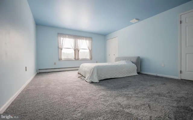 a spacious bedroom with a bed and a window