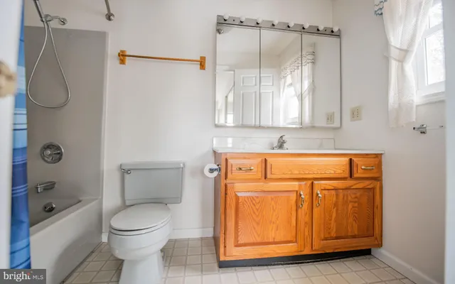 a bathroom with a granite countertop sink a toilet and shower