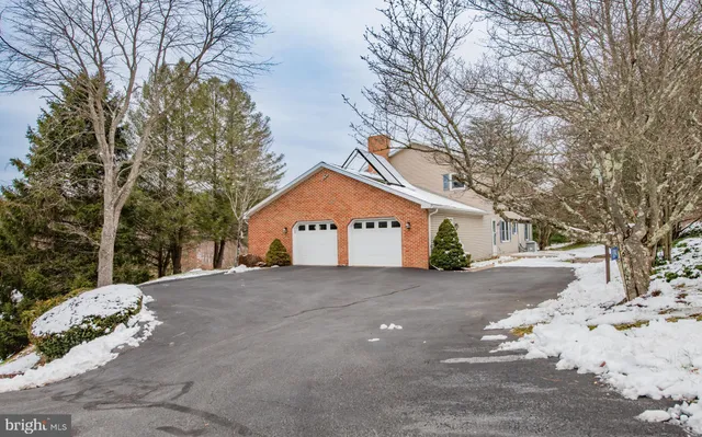 a view of a white house with a large tree