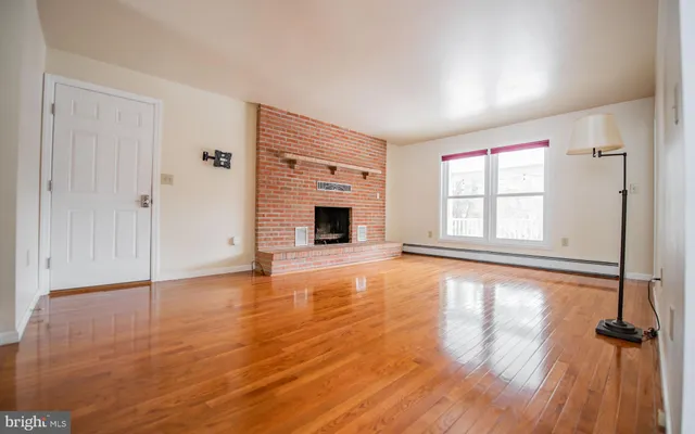 wooden floor fireplace and windows in an empty room
