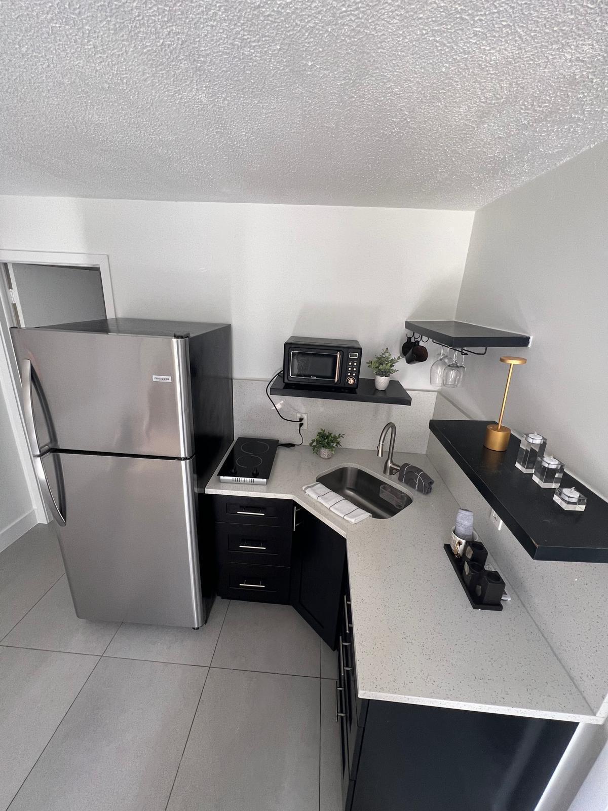 4791 Elmhurst Road, Unit A West Palm Beach, FL 33417 - Photo 3 of 8 a kitchen with a sink a stove and refrigerator
