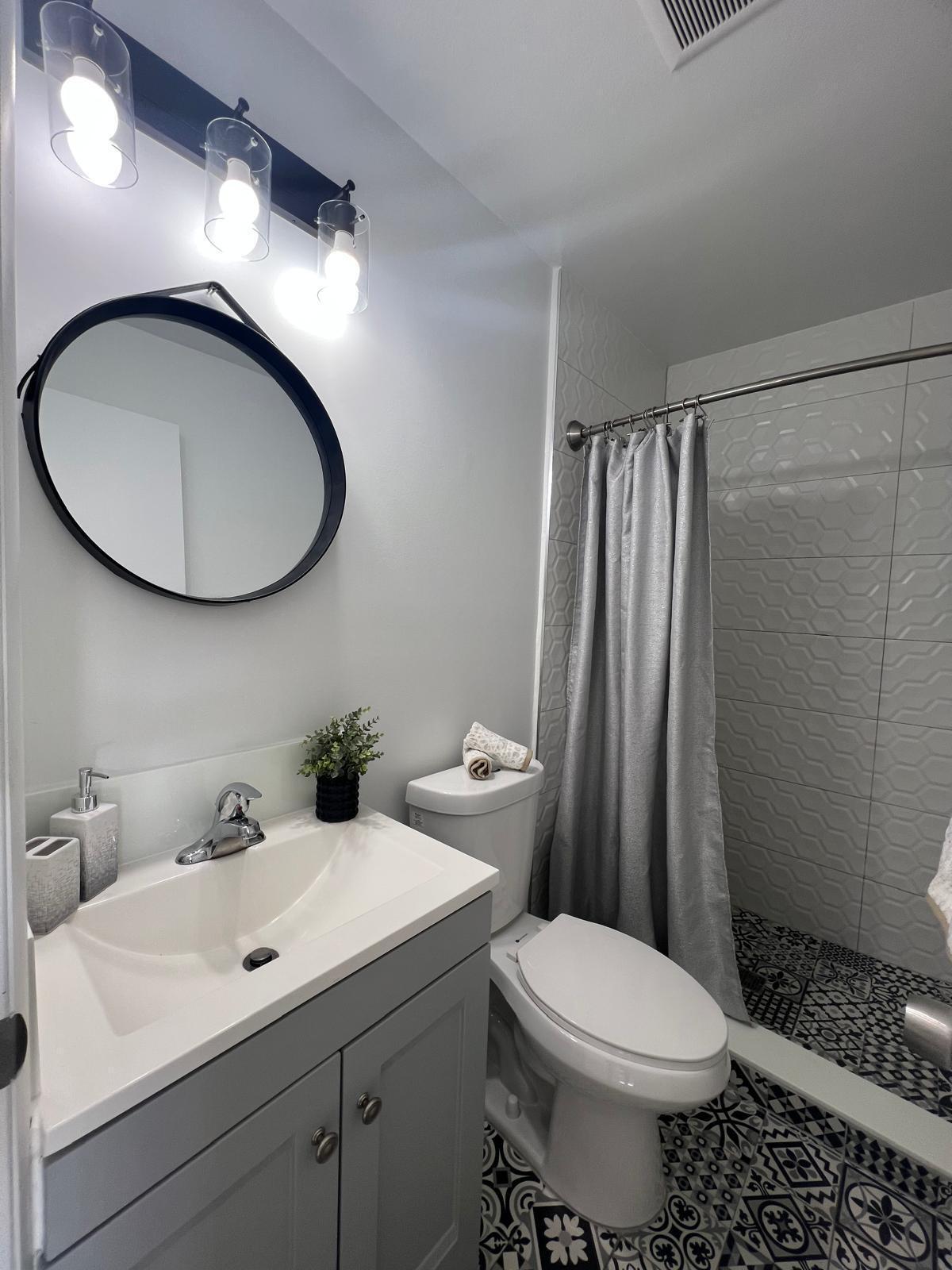 4791 Elmhurst Road, Unit A West Palm Beach, FL 33417 - Photo 6 of 8 a bathroom with a toilet sink and mirror