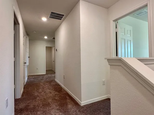 a view of a hallway with closet and wooden floor