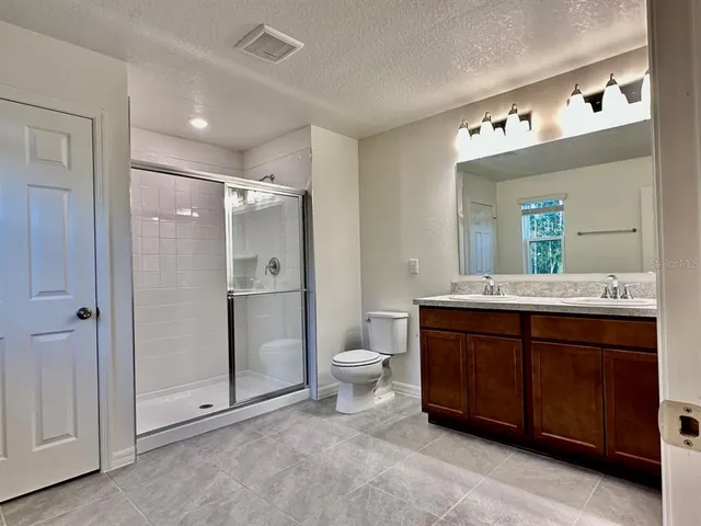 a bathroom with a double vanity sink a toilet and a mirror