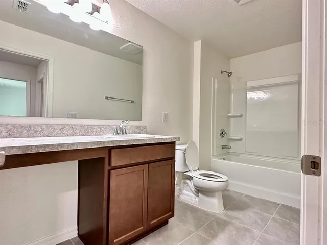 a bathroom with a sink a toilet a mirror and shower