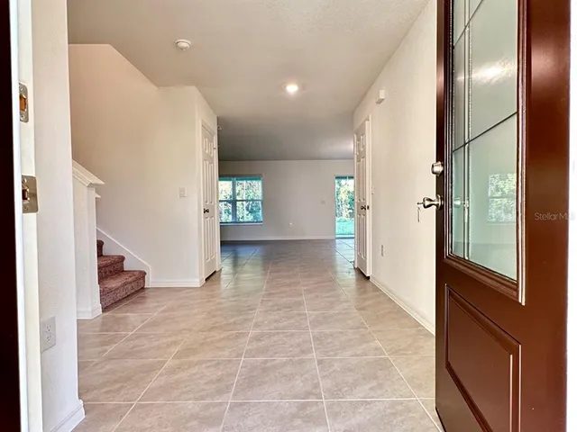 a view of a hallway with wooden floor and windows