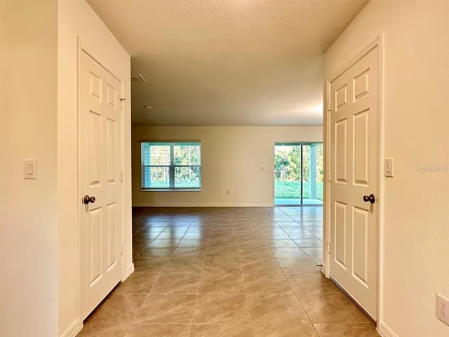 a view of a hallway with wooden floor and windows