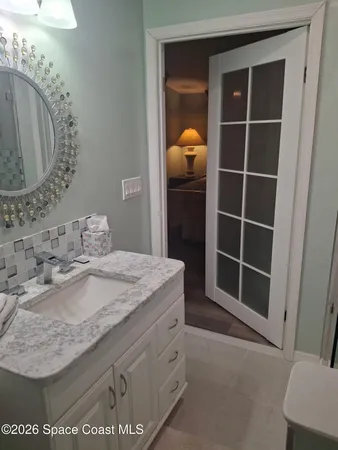 a bathroom with a granite countertop toilet a sink and a mirror