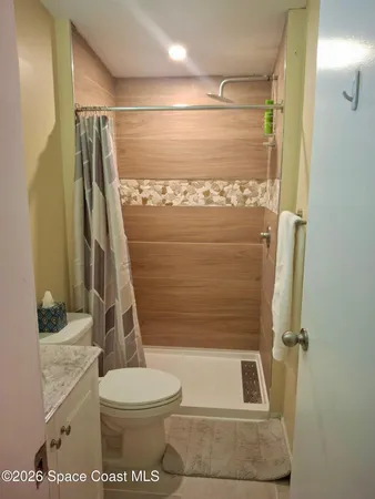 a bathroom with a granite countertop toilet sink and shower