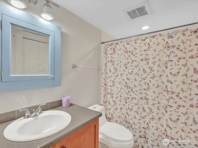 a bathroom with a sink toilet and mirror